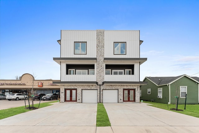 view of front of house featuring french doors, board and batten siding, concrete driveway, and an attached garage