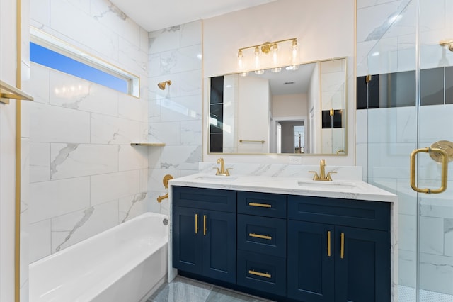 full bath with a sink, tile walls, and double vanity