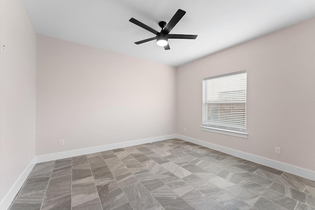 unfurnished room with baseboards and a ceiling fan