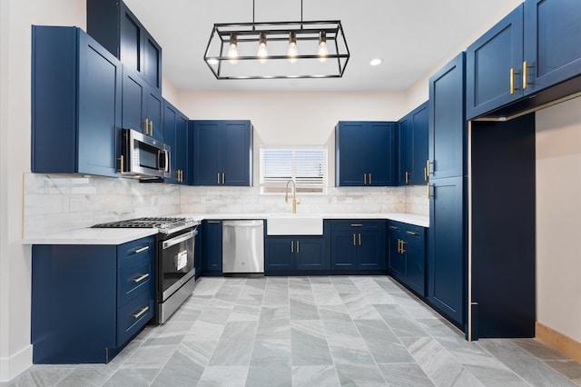 kitchen with blue cabinets, decorative backsplash, appliances with stainless steel finishes, and a sink