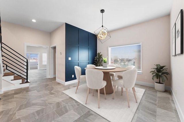 dining room featuring a healthy amount of sunlight, stairs, and baseboards