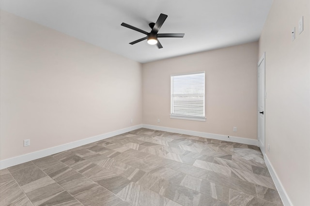 spare room featuring baseboards and ceiling fan