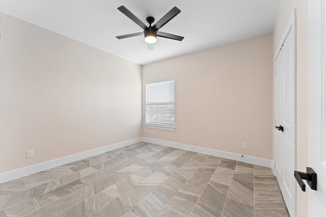 unfurnished room featuring baseboards and ceiling fan