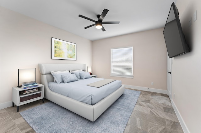 bedroom with a ceiling fan and baseboards