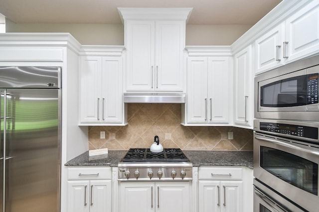 44 Tall Trl, Missouri City, TX 77459 - kitchen featuring under cabinet range hood, dark stone counters, decorative backsplash, built in appliances, and white cabinetry