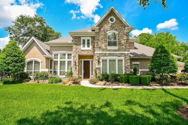 44 Tall Trl, Missouri City, TX 77459 - view of front of home featuring stone siding, a shingled roof, a front yard, and stucco siding