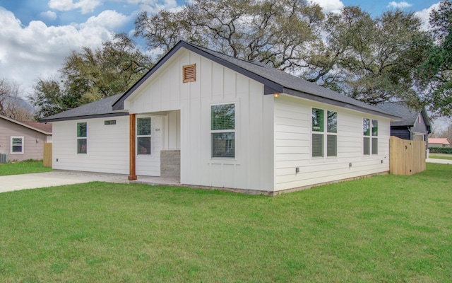 view of front facade featuring driveway, roof with shingles, board and batten siding, and a front yard