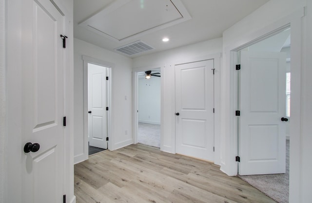 hallway with light wood-style flooring, recessed lighting, visible vents, baseboards, and attic access