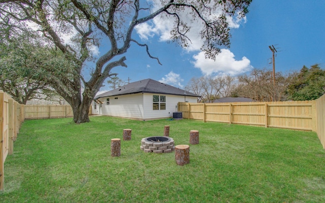 view of yard with a fenced backyard, a fire pit, and cooling unit