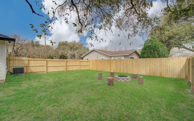 view of yard with a fenced backyard, a fire pit, and central air condition unit