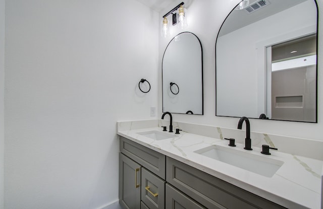 full bath with visible vents, a sink, and double vanity