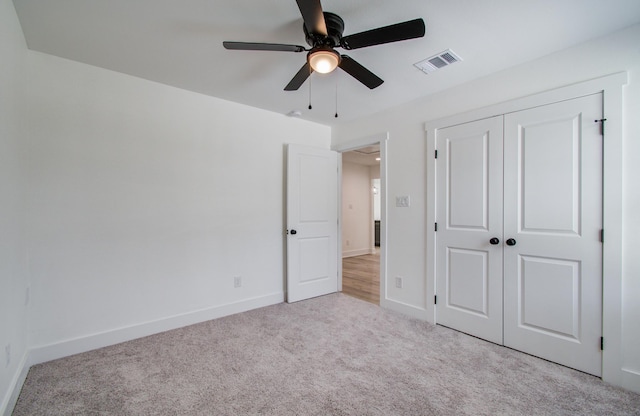 unfurnished bedroom featuring carpet floors, a closet, visible vents, and baseboards