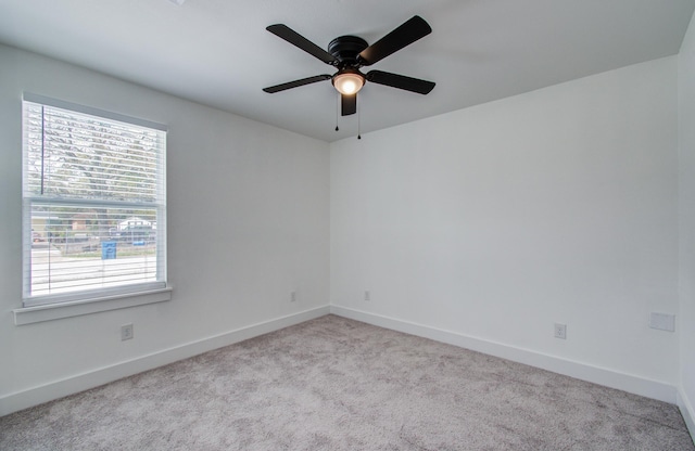 empty room with carpet flooring, ceiling fan, and baseboards