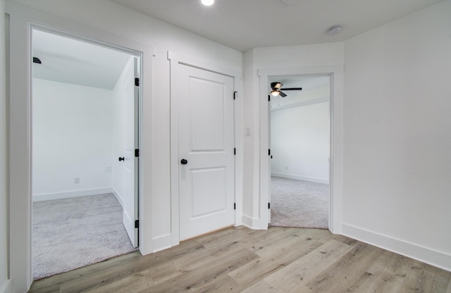 hallway featuring wood finished floors and baseboards