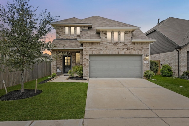 view of front facade featuring a garage, a front yard, brick siding, and fence