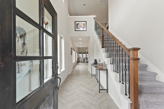 entryway with a towering ceiling, baseboards, stairway, and recessed lighting