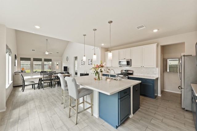 kitchen featuring visible vents, white cabinets, decorative backsplash, stainless steel appliances, and light countertops