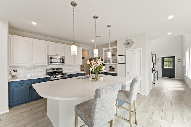 kitchen featuring stainless steel appliances, a sink, light countertops, and blue cabinets