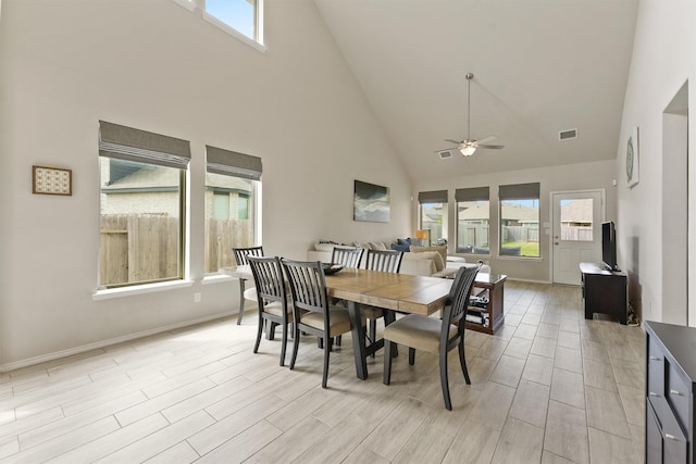 dining area with a wealth of natural light, ceiling fan, baseboards, and wood tiled floor