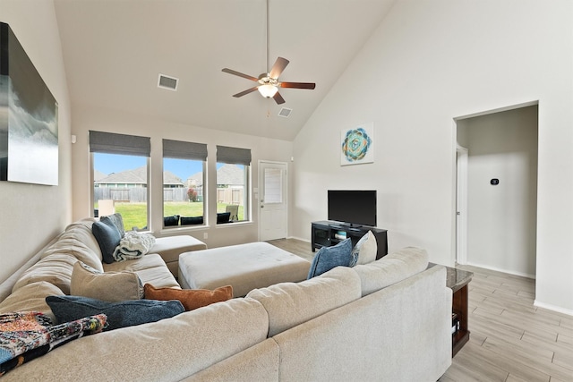 living area with high vaulted ceiling, a ceiling fan, baseboards, visible vents, and light wood-style floors