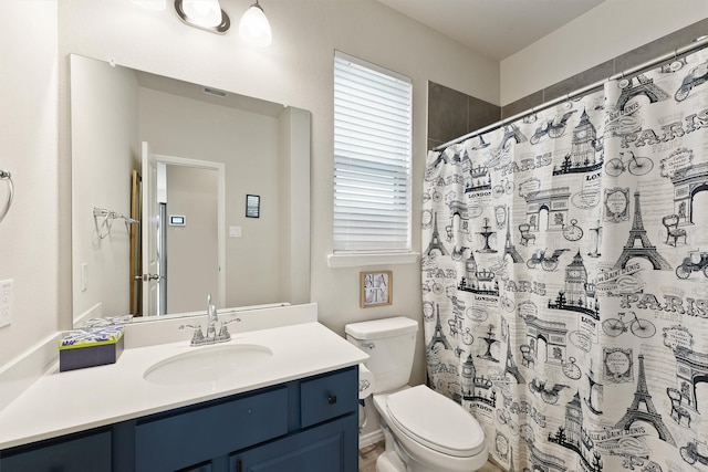 bathroom featuring toilet, curtained shower, visible vents, and vanity