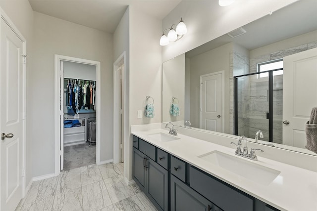 bathroom featuring marble finish floor, baseboards, a sink, and a stall shower