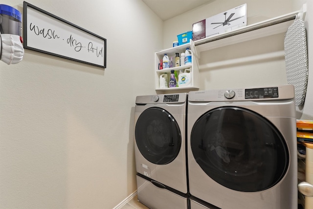 laundry room with laundry area, washing machine and clothes dryer, and baseboards