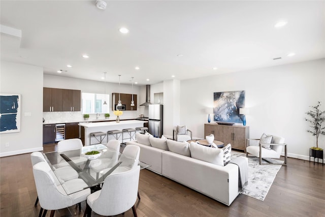 living room featuring baseboards, wine cooler, recessed lighting, and dark wood finished floors
