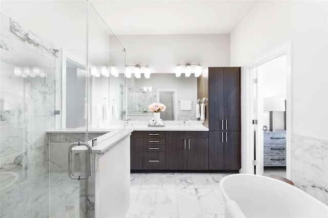 bathroom featuring marble finish floor, a freestanding bath, vanity, and a shower stall