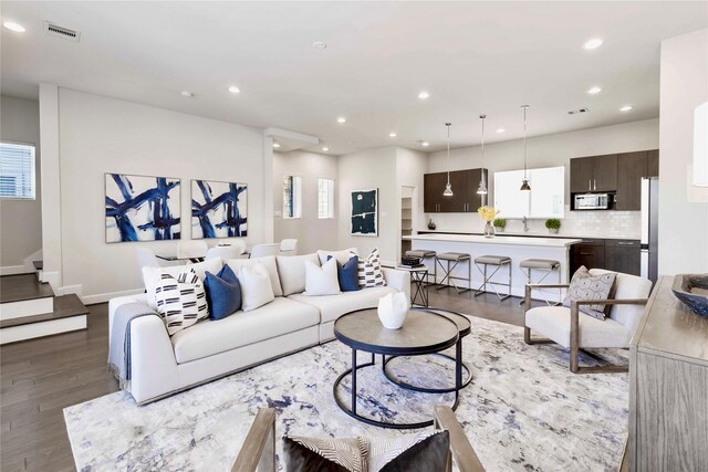 living room featuring stairway, wood finished floors, baseboards, visible vents, and recessed lighting