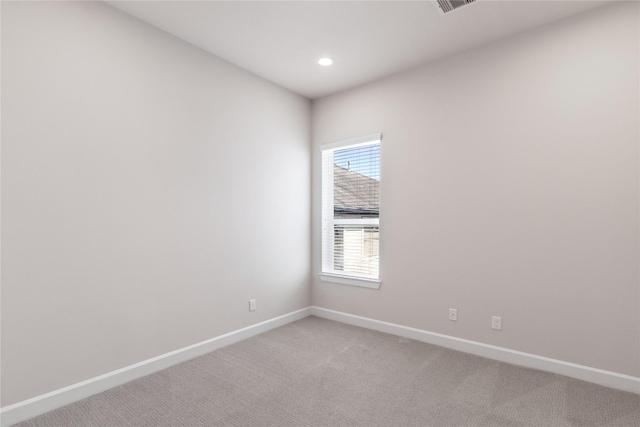 empty room with light colored carpet, recessed lighting, and baseboards