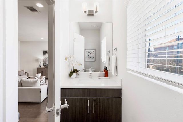 bathroom with visible vents, recessed lighting, wood finished floors, and vanity