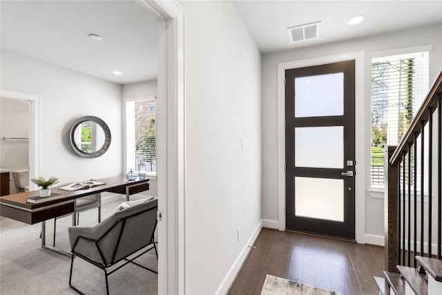 entryway with stairs, visible vents, hardwood / wood-style flooring, and a healthy amount of sunlight