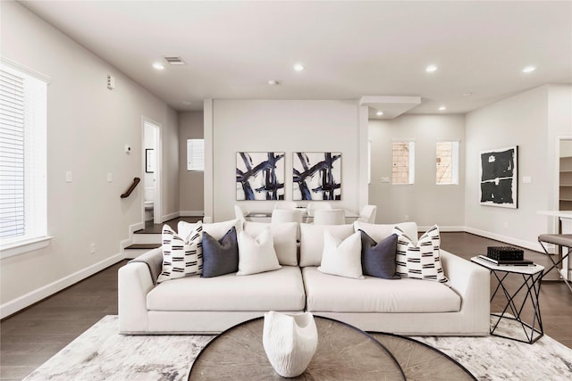 living area with baseboards, stairway, wood finished floors, and recessed lighting