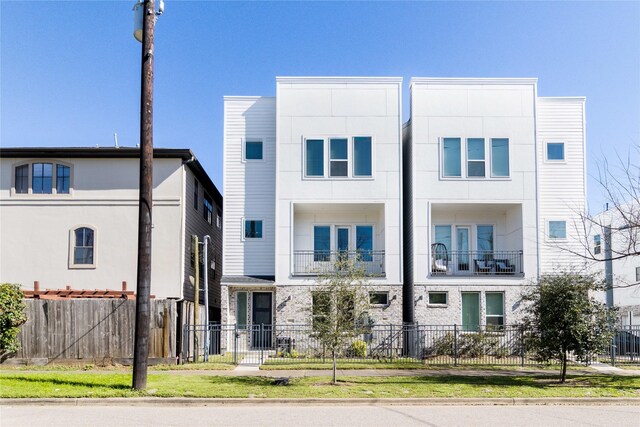 multi unit property featuring stucco siding and a fenced front yard