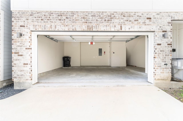 garage featuring electric panel, a garage door opener, and concrete driveway