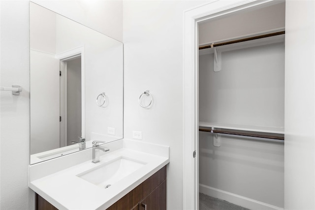 bathroom featuring vanity and a walk in closet