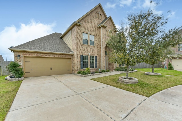 view of front facade featuring a garage, driveway, roof with shingles, a front yard, and brick siding