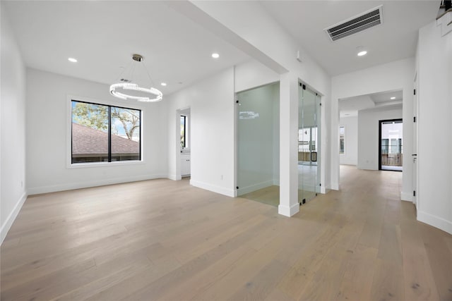 spare room featuring a notable chandelier, recessed lighting, visible vents, light wood-style flooring, and baseboards