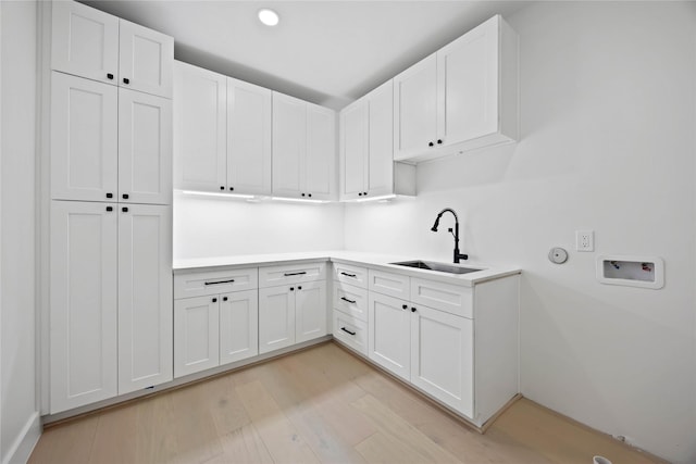 laundry area with washer hookup, recessed lighting, cabinet space, light wood-style floors, and a sink