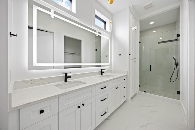 bathroom with marble finish floor, a sink, a shower stall, and double vanity