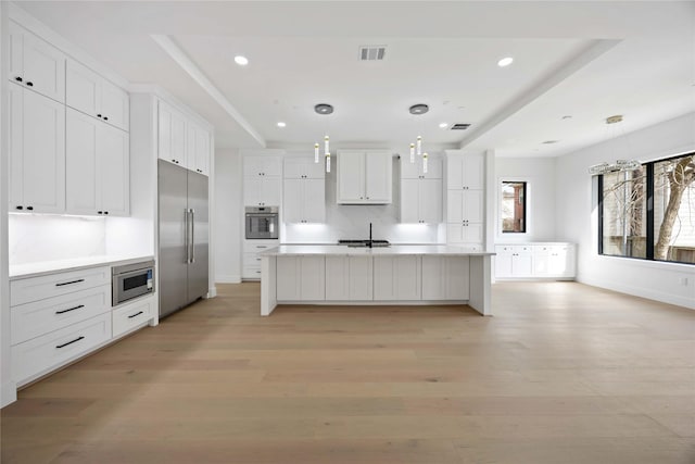 kitchen featuring light wood-style floors, white cabinetry, visible vents, and stainless steel appliances