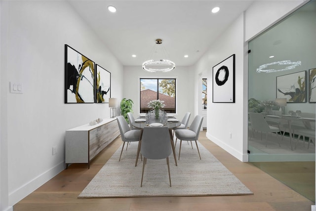 dining room with baseboards, a chandelier, wood finished floors, and recessed lighting