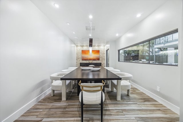 dining space featuring wood tiled floor, baseboards, and recessed lighting