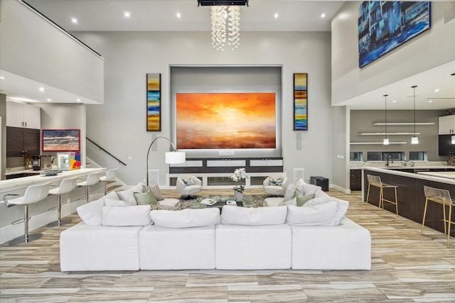 living area featuring recessed lighting, a towering ceiling, and stairs