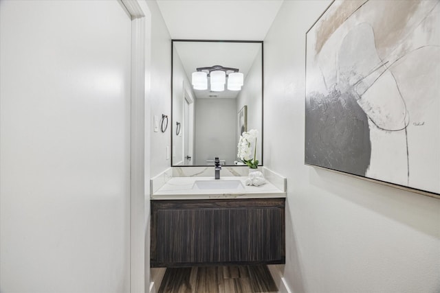 bathroom with baseboards, wood finished floors, and vanity