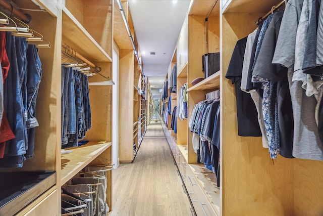 walk in closet with wood finished floors