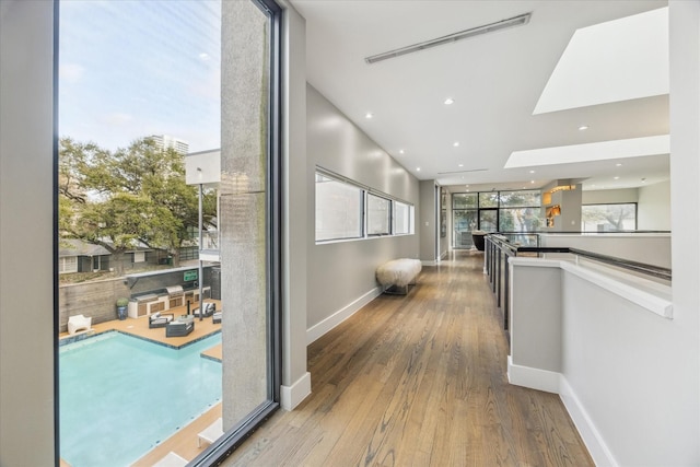 hall featuring visible vents, baseboards, wood finished floors, and recessed lighting