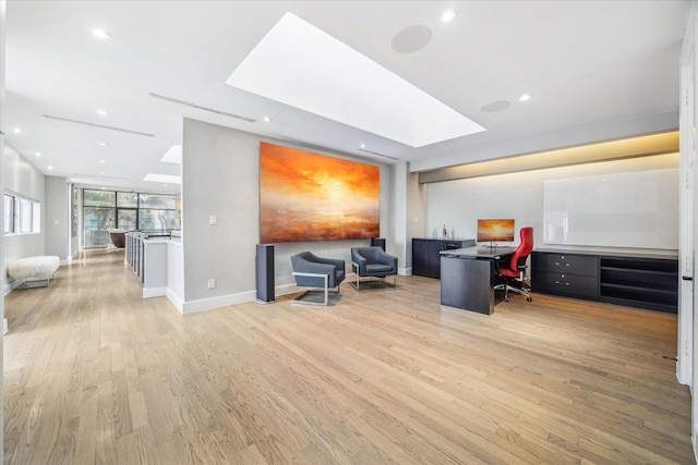 office with light wood-style floors, a skylight, baseboards, and recessed lighting