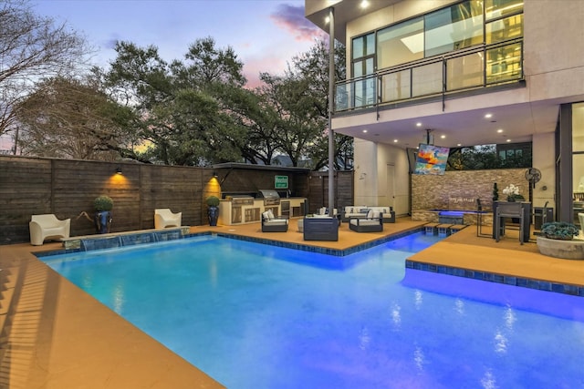 view of pool featuring a fenced in pool, a patio, outdoor lounge area, an outdoor kitchen, and fence